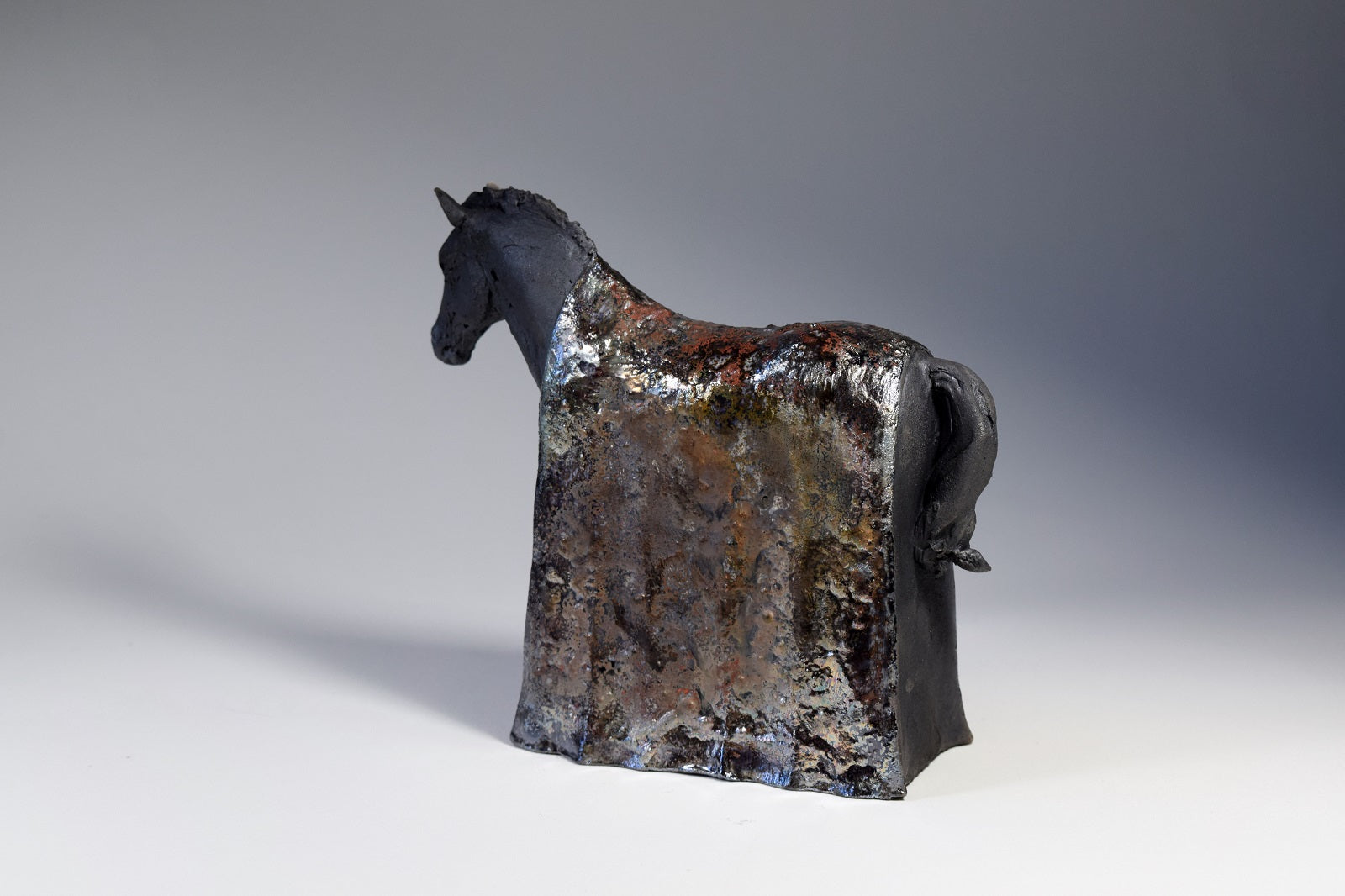 Ceramic raku horse sculpture with metallic blanket by Susie Benes