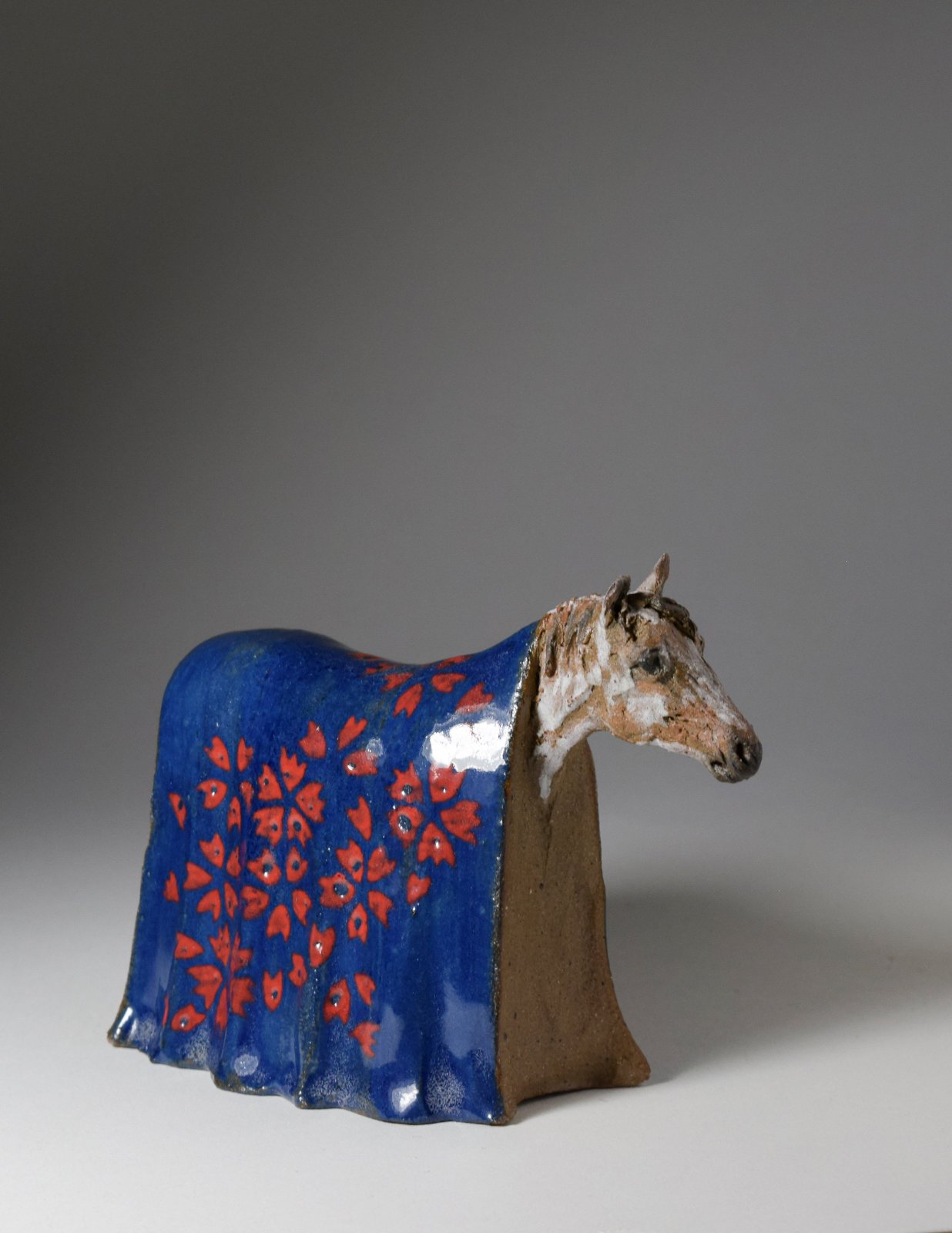 Small ceramic horse with blue blanket sculpture